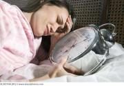 81712620_woman_laying_in_bed_with_giant_alarm_clock_bld027569-5808109